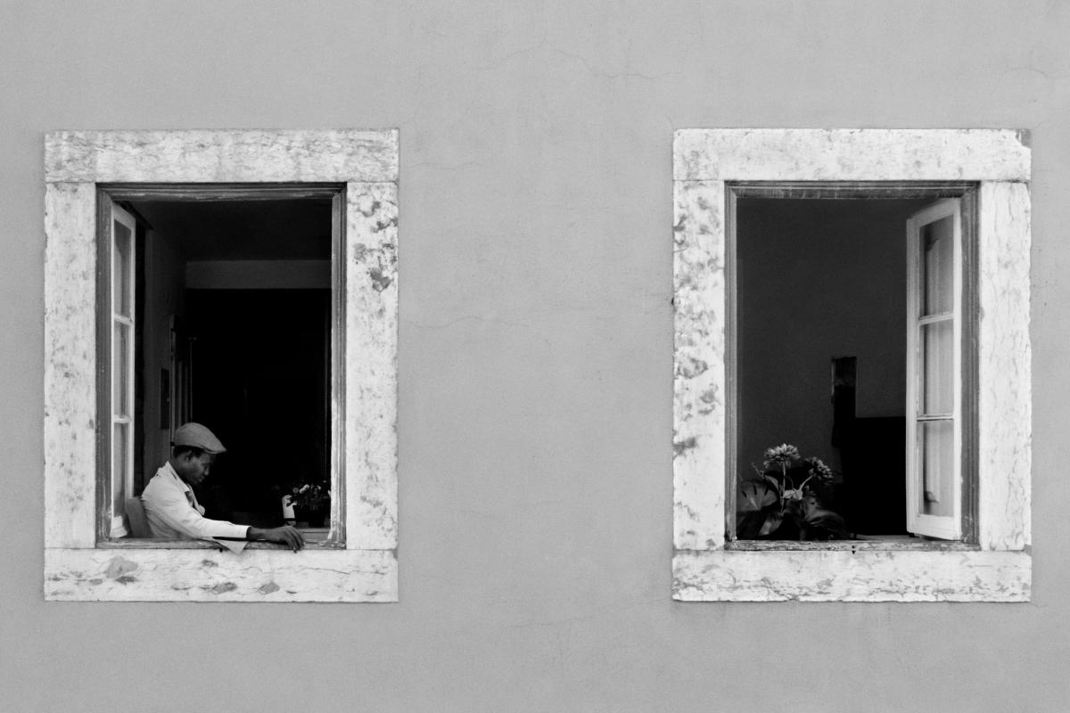 Due finestre su un muro, a una &egrave; affacciato un uomo, fotografia di Roberto Lugano