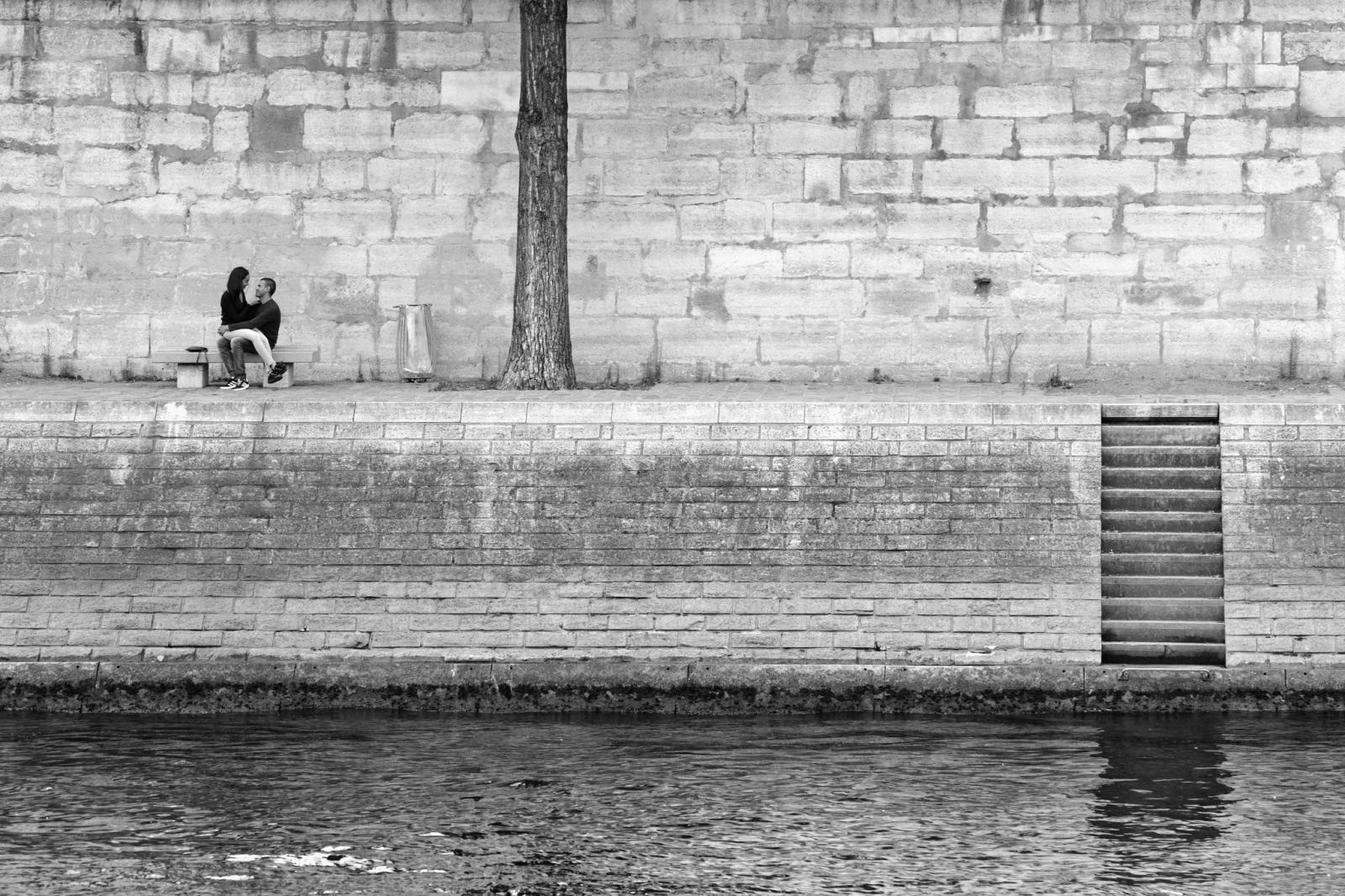 Una coppia seduta sul muro lungo un fiume, fotografia di Roberto Lugano