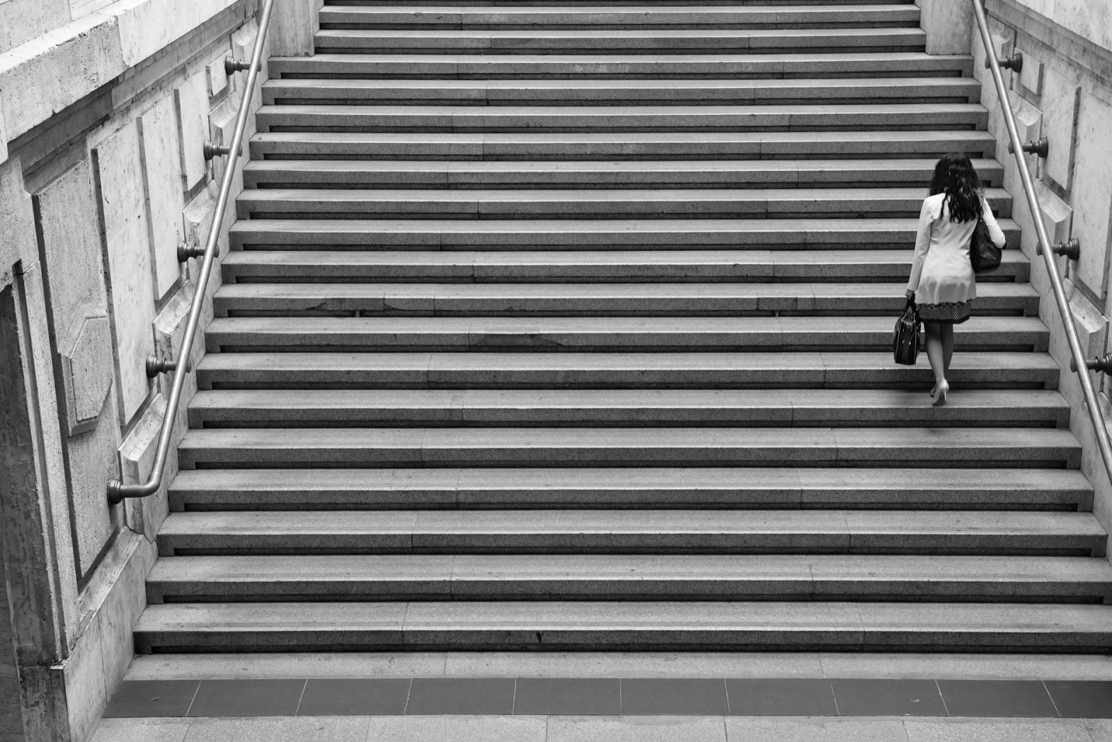 Una donna sale una lunga scalinata, fotografia di Roberto Lugano