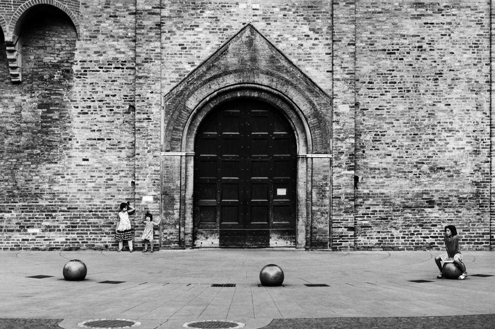 Bambini che giocano davanti al portale di una chiesa, fotografia di Roberto Lugano