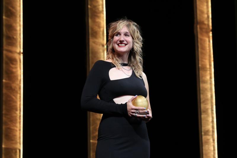 Una fotografa premiata sul palco con il trofeo