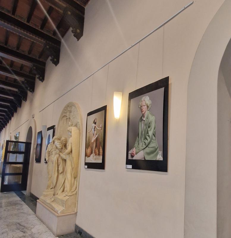 Ritratti fotografici esposti in un chiostro