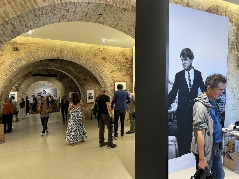 Visitatori in una mostra sotto le volte di mattoni